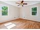 Cozy bedroom with hardwood floors, two windows for natural light, and a ceiling fan at 5632 Zion Church Rd, Concord, NC 28025
