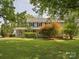Two-story home with front porch, well-maintained lawn, and mature trees offering shade at 5632 Zion Church Rd, Concord, NC 28025
