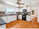 Bright kitchen with white cabinets, stainless steel appliances, and wood flooring at 5632 Zion Church Rd, Concord, NC 28025