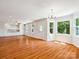 Open-concept living area with hardwood floors, ample natural light, and a view into the kitchen at 5632 Zion Church Rd, Concord, NC 28025