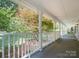 Inviting covered porch with white railings, offering a serene outdoor space with views of the yard at 5632 Zion Church Rd, Concord, NC 28025