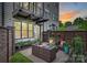 Private backyard patio featuring stone pavers, woven seating, garden, and tall windows, offering a serene outdoor retreat at 622 Mattie Rose Ln, Charlotte, NC 28204
