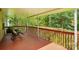 View of wooded backyard from covered wood deck with brown railings and patio furniture at 6530 Fly A Way Dr, Denver, NC 28037