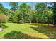 Large grassy backyard with many large trees, providing ample shade at 6530 Fly A Way Dr, Denver, NC 28037