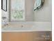 Close up of a soaking tub with chrome fixtures and natural light at 6530 Fly A Way Dr, Denver, NC 28037