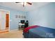 Well-lit blue bedroom with desk and view to hallway at 6530 Fly A Way Dr, Denver, NC 28037