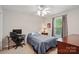Well-lit bedroom with a ceiling fan, desk area, and large window at 6530 Fly A Way Dr, Denver, NC 28037