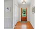 Inviting entryway featuring a wood door with glass panel, hardwood floors, and a convenient coat closet at 6530 Fly A Way Dr, Denver, NC 28037