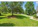 Grassy front yard with sidewalk and basketball hoop, with trees offering shade to the property at 6530 Fly A Way Dr, Denver, NC 28037