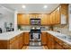 Well-lit kitchen boasts wooden cabinetry, stainless steel appliances, and laminate countertops at 6530 Fly A Way Dr, Denver, NC 28037