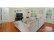 Comfortable living room showcasing hardwood floors, a neutral-toned sectional sofa, and bright natural light at 6530 Fly A Way Dr, Denver, NC 28037