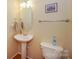 Cozy bathroom features a pedestal sink, framed art, and neutral color palette at 6873 Lakecrest Ct, Denver, NC 28037