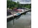Features a boat dock with multiple covered boats and paddle boards on calm water surrounded by lush green trees at 6873 Lakecrest Ct, Denver, NC 28037