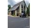 Exterior of a modern amenity center, showcasing stone accents, large windows, and a golf cart in the parking area at 6873 Lakecrest Ct, Denver, NC 28037