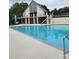 Community pool with an adjacent multi-story building with balconies and gated fence at 6873 Lakecrest Ct, Denver, NC 28037