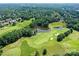 An aerial view of a lush green golf course featuring sand traps and picturesque ponds at 7010 Coventry Ct, Tega Cay, SC 29708