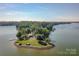 Aerial view of an island featuring a lakefront house and dock for mooring boats at 7010 Coventry Ct, Tega Cay, SC 29708