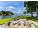 Beautiful backyard patio area with stone fire pit and Adirondack chairs overlooking the water at 7010 Coventry Ct, Tega Cay, SC 29708