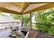 Outdoor balcony with comfortable seating and views of mature landscaping and the lake at 7010 Coventry Ct, Tega Cay, SC 29708