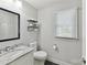 Clean bathroom with floating shelves, toilet, and granite countertop vanity at 7010 Coventry Ct, Tega Cay, SC 29708