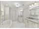 Bright and spacious bathroom with double vanities, granite counters, tub, and white cabinets at 7010 Coventry Ct, Tega Cay, SC 29708