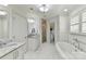 Bright bathroom with double vanity, soaking tub, and glass shower at 7010 Coventry Ct, Tega Cay, SC 29708