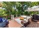 Spacious deck featuring plush seating, an umbrella for shade, and scenic views of the surrounding trees at 7010 Coventry Ct, Tega Cay, SC 29708