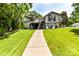 Exterior of a waterfront home with multiple decks, a well-manicured lawn, and a charming pathway at 7010 Coventry Ct, Tega Cay, SC 29708