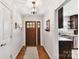 A warm foyer with hardwood floors, a wooden door, and access to the kitchen at 7010 Coventry Ct, Tega Cay, SC 29708