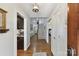 A foyer with hardwood floors, stairs, and views of a kitchen and living room at 7010 Coventry Ct, Tega Cay, SC 29708