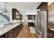 Modern kitchen featuring dark cabinetry, granite counters, and stainless steel appliances at 7010 Coventry Ct, Tega Cay, SC 29708