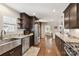 Well-lit kitchen boasts stainless steel appliances, granite countertops, and dark wood cabinets at 7010 Coventry Ct, Tega Cay, SC 29708