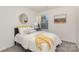 Cozy bedroom features a large window, soft bedding, round mirror and a side table with a lamp at 7109 N Mills Rd, Charlotte, NC 28216