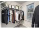Walk-in closet with ample storage, rod system and shelving near a window for natural light at 7109 N Mills Rd, Charlotte, NC 28216