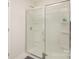Enclosed shower featuring a sliding glass door, chrome fixtures and built-in shelving at 7109 N Mills Rd, Charlotte, NC 28216