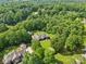 Expansive aerial view of a beautiful home nestled among lush trees, offering privacy and scenic beauty at 7612 Maple Bluff Ln, Concord, NC 28025