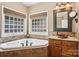 A luxurious primary bathroom features a soaking tub with mosaic tile surround at 7612 Maple Bluff Ln, Concord, NC 28025
