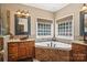Bathroom with tile surround tub and double granite vanity at 7612 Maple Bluff Ln, Concord, NC 28025