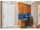 Built-in desk with natural wood cabinets and drawers, with computer and view of front door at 7612 Maple Bluff Ln, Concord, NC 28025