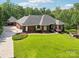 Gorgeous exterior view of the brick home with well-maintained lawn, lush landscaping, and detached garage at 7612 Maple Bluff Ln, Concord, NC 28025