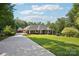 Elegant brick home featuring a detached garage, expansive lawn, and meticulously maintained landscaping at 7612 Maple Bluff Ln, Concord, NC 28025