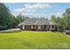 Charming brick home showcasing a beautiful lawn, mature shrubs, and classic architectural details at 7612 Maple Bluff Ln, Concord, NC 28025