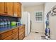 Bright laundry area with natural wood cabinets and drawers, and an adjacent refrigerator at 7612 Maple Bluff Ln, Concord, NC 28025