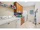 Spacious laundry room featuring tiled floors, modern appliances, and ample cabinet space for storage at 7612 Maple Bluff Ln, Concord, NC 28025