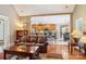 Comfortable living room with hardwood floors, large leather sofa, and an open view to the kitchen and dining area at 7612 Maple Bluff Ln, Concord, NC 28025