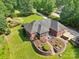 Aerial shot of the brick home back exterior showcasing a screened-in porch and landscaped garden at 7612 Maple Bluff Ln, Concord, NC 28025