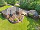 Aerial view of the rear exterior featuring brick home, screened porch, patio, landscaped terraced garden at 7612 Maple Bluff Ln, Concord, NC 28025