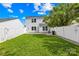 A well-kept backyard with lush green grass, a white fence, and the rear view of the two-story house at 8614 Westhope St, Charlotte, NC 28216