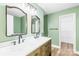 Bathroom with double vanity, modern faucets, decorative mirrors, and warm green walls at 8614 Westhope St, Charlotte, NC 28216