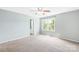 Bright bedroom features a ceiling fan, a large window, and neutral carpeting at 8614 Westhope St, Charlotte, NC 28216
